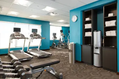 a gym with cardio equipment and blue walls at Fairfield Inn & Suites by Marriott Sacramento Folsom in Folsom