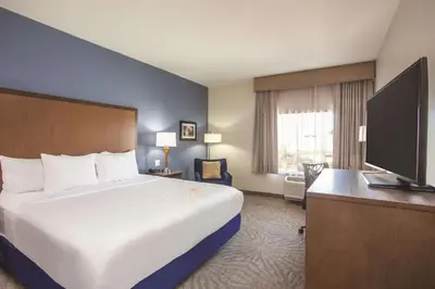 a hotel room with a bed and a flat screen tv at La Quinta by Wyndham Morgan Hill-San Jose South in Morgan Hill