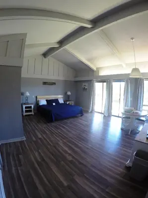 a large bedroom with a bed and a wooden floor at Ridgemark Golf Club and Resort in Hollister