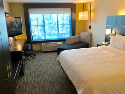 a hotel room with a bed and a desk and a television at Holiday Inn Express & Suites Tracy by IHG in Tracy