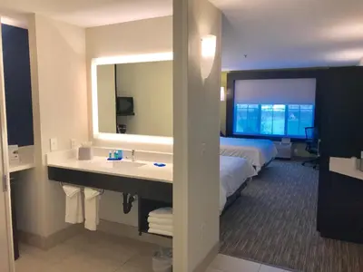 a hotel room with a sink and a bed at Holiday Inn Express & Suites Tracy by IHG in Tracy