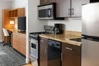 a kitchen with stainless steel appliances and wooden cabinets at TownePlace Suites by Marriott Sacramento Roseville in Roseville