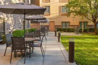 a row of tables and chairs with umbrellas on a sidewalk at TownePlace Suites by Marriott Sacramento Roseville in Roseville