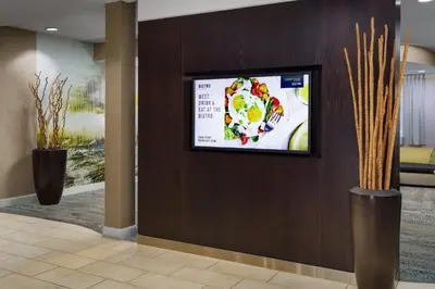 a flat screen tv on a wall in a lobby at Courtyard by Marriott Roseville Galleria Mall/Creekside Ridge Drive in Roseville