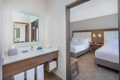 a hotel room with a bed and a sink and a mirror at Holiday Inn Express Hotel & Suites Bishop by IHG in Bishop