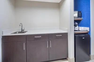 a kitchen with a sink and a refrigerator at Holiday Inn Express Hotel & Suites Bishop by IHG in Bishop