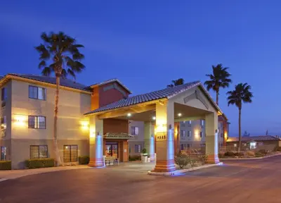 a hotel with palm trees in front of a building at Holiday Inn Express Westley by IHG in Westley