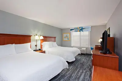 a hotel room with two beds and a flat screen tv at Hampton Inn & Suites Clovis Airport North in Clovis