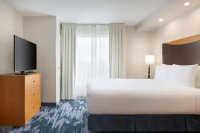 a hotel room with a bed and a flat screen tv at Fairfield Inn and Suites Turlock in Turlock