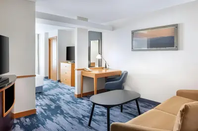 a hotel room with a desk and a chair at Fairfield Inn and Suites Turlock in Turlock