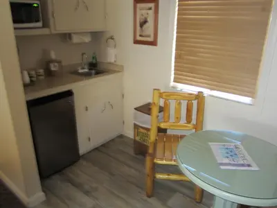 a small kitchen with a table and a table and chairs at Sequoia Lodge in Kernville