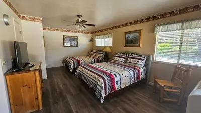 a bedroom with two beds and a television in it at Sequoia Lodge in Kernville