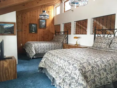 a bedroom with two beds and a tv in it at Chateau Royal East in Yosemite West