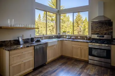 a kitchen with wooden cabinets and a large window at Alpenglow 3 in Yosemite West