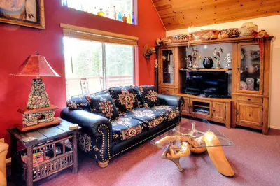 a living room with a couch and a tv at Christmas Cabin in Yosemite West
