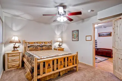 a bedroom with a wooden bed with a ceiling fan at Explorers Retreat in Yosemite West