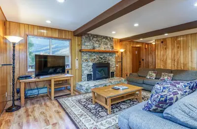 a living room with a couch and a fireplace at Hutchings Cabin & Apt. in Yosemite West