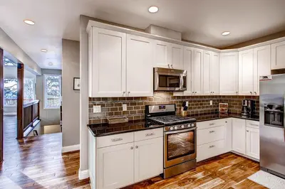 a kitchen with white cabinets and a stove top oven at Kildrummy Lodge in Yosemite West