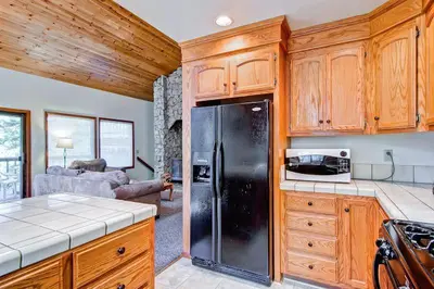 a kitchen with wooden cabinets and a black refrigerator at Sport Chalet in Yosemite West