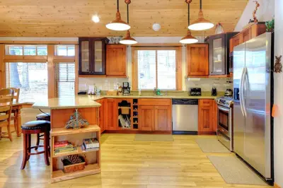 a kitchen with wooden cabinets and a stainless steel refrigerator at Strawberry Creek in Yosemite West
