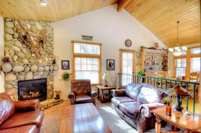 a living room with leather furniture and a stone wall at Strawberry Creek in Yosemite West