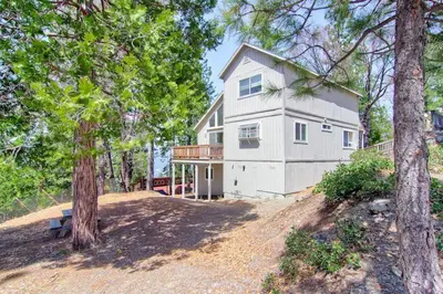 a large white house on a hill with trees at Yosemite Park Place in Yosemite West