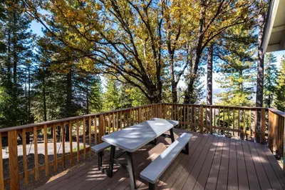 a deck with a table and a bench on it at Yosemite Park Place in Yosemite West