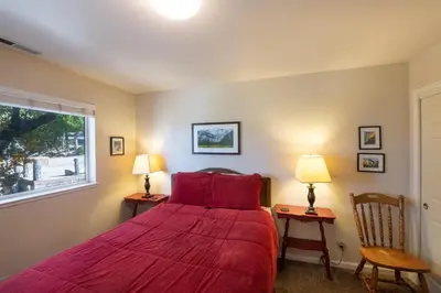 a bedroom with a red bed and two chairs at Yosemite Park Place in Yosemite West