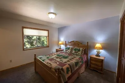 a bedroom with a bed and two lamps and a window at Quail Crossing Lodge in Yosemite West