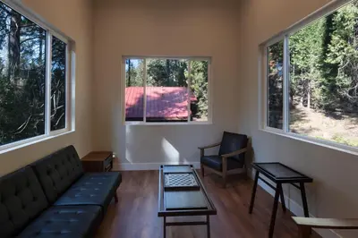 a living room with a couch and two chairs and windows at Boulder Ridge in Yosemite West