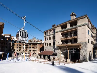 a ski lift in front of a building in the snow at The Residences at One Village Place by Hyatt Vacation Club in Truckee