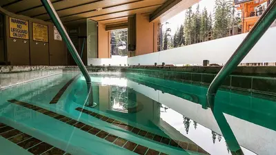 a swimming pool with a reflection in the water at The Residences at One Village Place by Hyatt Vacation Club in Truckee