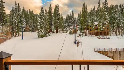 a snow covered park with trees and a building at The Residences at One Village Place by Hyatt Vacation Club in Truckee