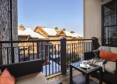 a balcony with a couch and a table at The Residences at One Village Place by Hyatt Vacation Club in Truckee