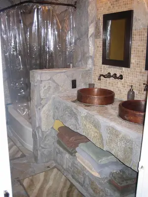 a stone bathroom with two sinks and a tub at Alta Peak Vista in Three Rivers