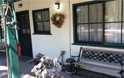 a house with a bench in front of a building at Kern Riverfront Lodge in Kernville