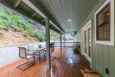 a covered porch with a table and chairs on it at Yosemite Sierra Blossom in Yosemite West
