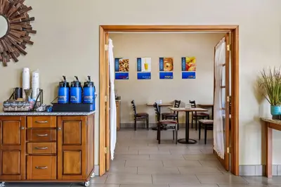 a kitchen and dining room with a table with chairs at Best Western Liberty Inn in Delano