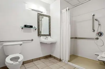 a bathroom with a toilet and a sink and a shower at Best Western Liberty Inn in Delano