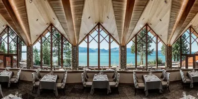 a restaurant with tables and chairs in a room with windows at Edgewood Tahoe Resort in Stateline