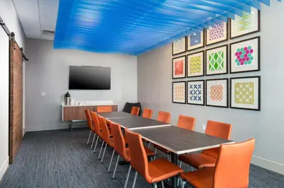 a conference room with a long table and orange chairs at Holiday Inn Express Visalia-Sequoia Gateway Area by IHG in Visalia