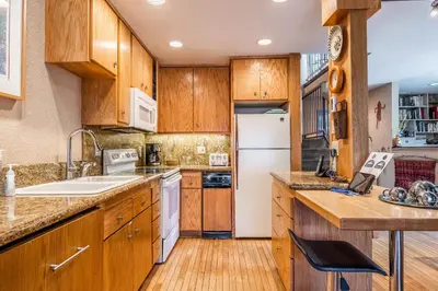 a kitchen with wooden cabinets and a white refrigerator at Chamonix # 92 in Mammoth Lakes