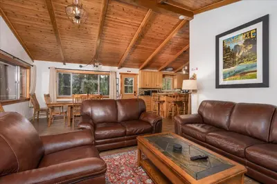 a living room with leather furniture and a table at Evergreen in Wawona