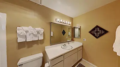 a bathroom with a sink and a toilet and a mirror at Spacious 3 Bedroom Condo with Loft! in Mammoth Lakes