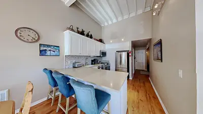 a kitchen with a counter with blue chairs and a clock at Spacious 3 Bedroom Condo with Loft! in Mammoth Lakes