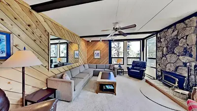 a living room with a couch and a stone wall at Great Condo With Free Shuttle to the Village! in Mammoth Lakes