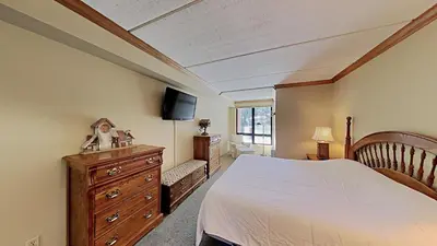 a bedroom with a bed and a dresser and a tv at Lakeview 826 Condo #108 Condo in Mammoth Lakes