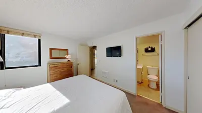 a bedroom with a white bed and a bathroom at Spacious Condo Great For Friends And Families! in Mammoth Lakes