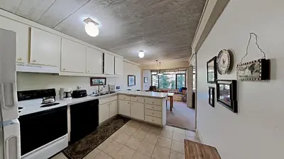 a kitchen with white cabinets and black appliances at Spacious Condo Great For Friends And Families! in Mammoth Lakes