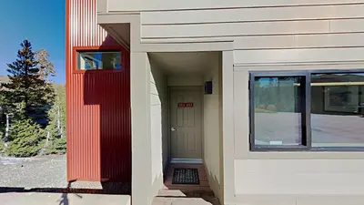 a building with a red door and a window at Lakeview 826 Condo #553 Condo in Mammoth Lakes
